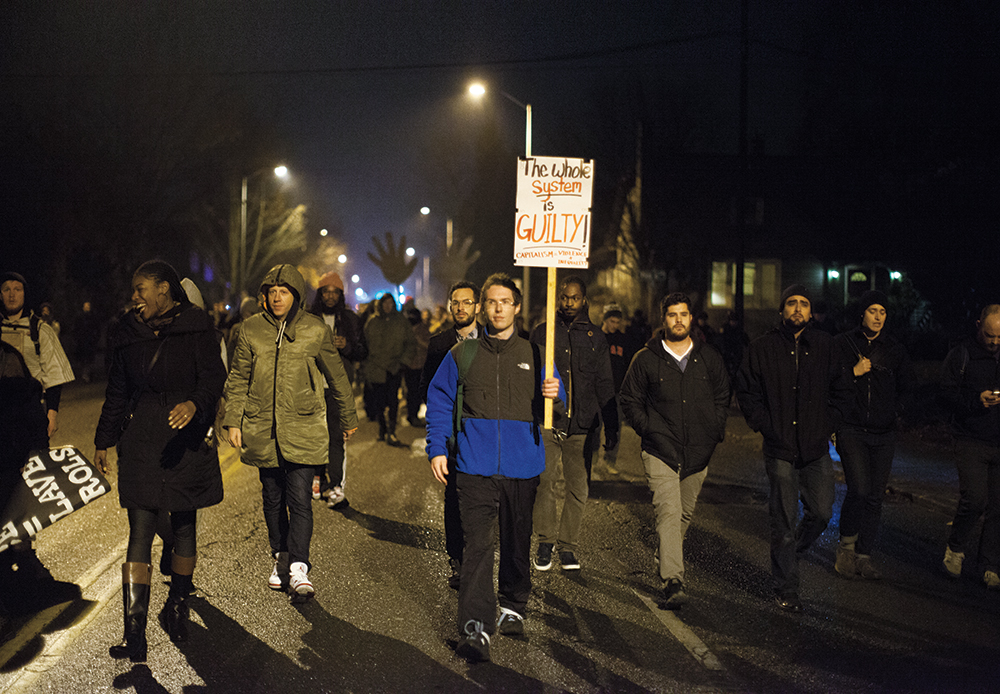 Macklemore marching in Seattle 2014. Image via Alex Gartland