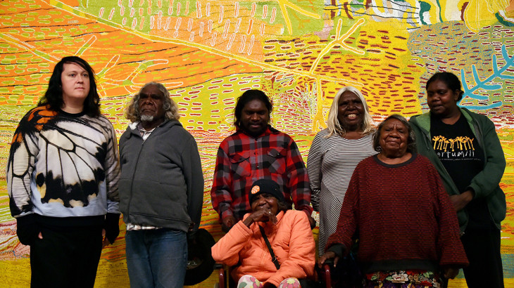 Singer Antony Hegarty (L) poses with Aboriginal artists in front of the painting 'Kalyu', meaning water, at Sydney's Museum of Contemporary Art on June 22, 2015. The Aboriginal group is protesting a proposed uranium mine on their land in Australia's remote far northwest on the edge of the Great Sandy Desert. Hegarty, best known for his work with Antony and the Johnsons, said he supported the protest and that environmental issues were a global problem.AFP PHOTO / Saeed KHAN        (Photo credit should read SAEED KHAN/AFP/Getty Images)