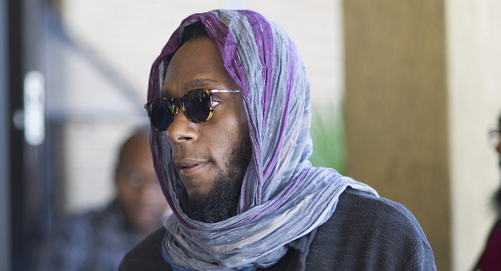 Us hip hop artist and actor, Yasiin Bey, popularly known as Mos Def, walks into the Bellville Magistrates Court, to appear for contravening South African immigration laws, on March 8, 2016, in Cape Town. 

Mos Def was arrested trying to leave, at Cape Town airport, with a"world passport" which South African authorities did not recognize as a legal travel document. Bey claims he has used this document to travel before. / AFP / Rodger BOSCH        (Photo credit should read RODGER BOSCH/AFP/Getty Images)